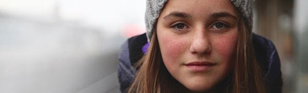 Young girl with long brown hair wearing a grey beanie